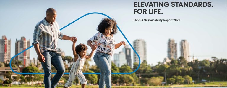 Cover of ENVEA's Sustainability Report 2023, featuring a family enjoying a sunny day in a park with a city skyline in the background. The title 'Elevating Standards. For Life.' reflects ENVEA's commitment to sustainability and environmental stewardship. The design emphasises a balance between urban living and nature.